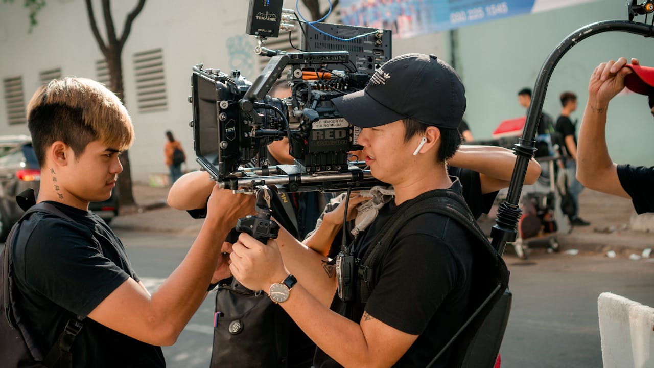 Cinematographers setting up professional video gear on an outdoor film set.